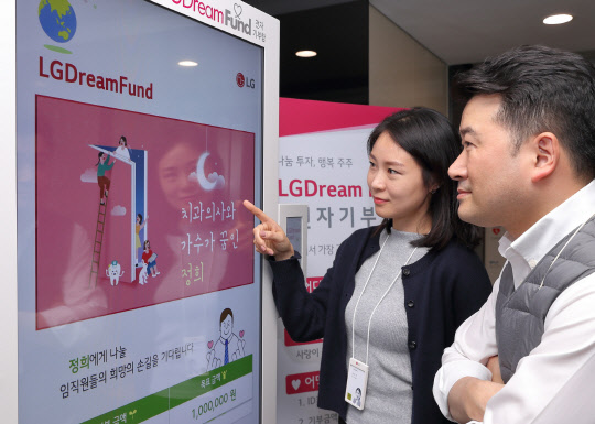 LG디스플레이 임직원들이 사내 전자기부함에 소개한 지역사회 이웃의 사연을 보고 사원증을 접촉해 기부하고 있다. <LG디스플레이 제공>